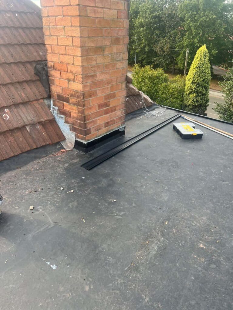 This is a photo of a flat roof which has just been repaired, there is also a chimney stack and some leadwork has also been dressed. Works carried out by Upper Stoke Roofing Repairs